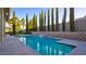 Sparkling pool with waterfall feature and lush landscaping at 6120 Kings Brook Ct, Las Vegas, NV 89149