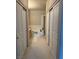 Hallway view of a neutral bathroom, including a large tub, tile surround, and sliding doors for privacy at 656 Peachy Canyon Cir # 203, Las Vegas, NV 89144