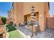 Inviting backyard featuring a covered patio, artificial grass, rock landscaping, and a shady umbrella at 7704 Lots Hills Dr, Las Vegas, NV 89179