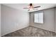 This bedroom features neutral paint, carpet, a window and a ceiling fan at 7704 Lots Hills Dr, Las Vegas, NV 89179