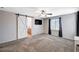 Spacious bedroom features a sliding barn door entrance to the bathroom, ceiling fan, and ample light at 7704 Lots Hills Dr, Las Vegas, NV 89179