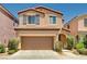 Two-story home with a two-car garage, desert landscaping, and a tile roof exudes curb appeal at 7704 Lots Hills Dr, Las Vegas, NV 89179