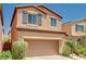 This two-story home features a two-car garage and desert landscaping at 7704 Lots Hills Dr, Las Vegas, NV 89179