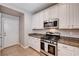Bright kitchen features stainless steel appliances, granite countertops, and white cabinetry at 7704 Lots Hills Dr, Las Vegas, NV 89179