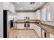 Well-lit kitchen boasts stainless steel appliances, granite counters, and ample white cabinetry at 7704 Lots Hills Dr, Las Vegas, NV 89179
