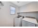 Bright laundry room features a window and a set of front-load washer and dryer at 7704 Lots Hills Dr, Las Vegas, NV 89179