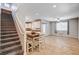 Open-concept living area with tile flooring, stairs, dining table, and natural light through windows at 7704 Lots Hills Dr, Las Vegas, NV 89179