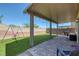 Inviting backyard with pavers, artificial grass, covered patio, and a swing set at 7720 Houston Peak St, Las Vegas, NV 89166