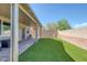 Lush backyard with artificial grass, a covered patio, and a charming swing set at 7720 Houston Peak St, Las Vegas, NV 89166