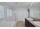 Bright bathroom with a soaking tub, glass shower, double sinks with modern fixtures and neutral countertops at 7720 Houston Peak St, Las Vegas, NV 89166