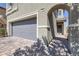 Home exterior showcasing the front entrance, brick driveway, and a gray two-car garage at 7720 Houston Peak St, Las Vegas, NV 89166