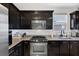 Modern kitchen showcasing dark cabinetry, granite countertops, and stainless steel appliances at 7720 Houston Peak St, Las Vegas, NV 89166