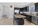 Stylish kitchen with dark cabinets, stainless steel appliances, and an island with seating at 7720 Houston Peak St, Las Vegas, NV 89166