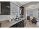 View of kitchen wet bar area with dark cabinetry and granite countertops at 7720 Houston Peak St, Las Vegas, NV 89166