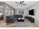 Bright living room featuring a ceiling fan, gray sofa, tile floor, and view to dining area at 7720 Houston Peak St, Las Vegas, NV 89166