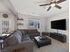 Open-concept living room with gray sofa, tile flooring, and access to the backyard patio at 7720 Houston Peak St, Las Vegas, NV 89166