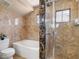 Elegant bathroom featuring a soaking tub, separate glass shower and brown marble-tiled walls at 7924 Mcdowell Dr, Las Vegas, NV 89129