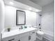 Bathroom vanity with white countertops and black fixtures with shower-tub combo in an all white modern bathroom at 849 Brahma Ln, Henderson, NV 89002