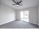 This bedroom features a ceiling fan, neutral paint, and a sliding door to the yard at 849 Brahma Ln, Henderson, NV 89002