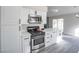 Bright kitchen features white cabinets, quartz countertops, and stainless steel appliances at 849 Brahma Ln, Henderson, NV 89002