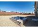 Backyard featuring a hot tub set in stone, surrounded by gravel and a brick wall at 8753 Mann St, Las Vegas, NV 89139