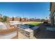 Backyard with a hot tub, sitting area, and manicured green space at 8753 Mann St, Las Vegas, NV 89139