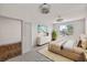 Staged bedroom with neutral carpet, modern lighting, and a bright window with neighborhood views at 8753 Mann St, Las Vegas, NV 89139
