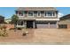 A two-story home with stone accents, desert landscaping, and a brick paved driveway at 8753 Mann St, Las Vegas, NV 89139