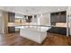 Modern kitchen with a large island, stainless steel appliances, dark cabinets, and hardwood floors at 8753 Mann St, Las Vegas, NV 89139