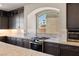 Gourmet kitchen features stainless steel appliances and dark cabinetry at 8753 Mann St, Las Vegas, NV 89139