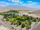 Scenic aerial view of the property featuring a lush pond, mature trees, and the stunning backdrop of mountains at 8808 Homestead Rd, Las Vegas, NV 89143