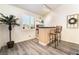 Cozy bar area with wood floors, two chairs, neutral walls, and a pass through window at 8808 Homestead Rd, Las Vegas, NV 89143