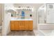 Bright bathroom featuring a double vanity, large mirror, glass-enclosed shower, and tile flooring at 8808 Homestead Rd, Las Vegas, NV 89143