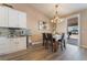 Cozy dining area with a stylish chandelier, seamlessly connected to the outdoor patio, perfect for indoor-outdoor dining at 8808 Homestead Rd, Las Vegas, NV 89143