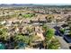 Aerial view of a residential neighborhood featuring mature landscaping, tile roofs and a view of distant mountains at 902 Cripple Creek Ct, Henderson, NV 89014