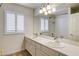 Bathroom with dual sinks, large mirror, and shower, complemented by plantation shutters at 902 Cripple Creek Ct, Henderson, NV 89014