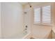 Well-lit bathroom featuring a tub with tile surround and shuttered window at 902 Cripple Creek Ct, Henderson, NV 89014