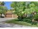 Well-maintained home with a green lawn and mature trees, featuring a three-car garage and terracotta roof at 902 Cripple Creek Ct, Henderson, NV 89014