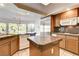 Open kitchen featuring wooden cabinets, stainless steel appliances, granite countertops, and tile flooring at 902 Cripple Creek Ct, Henderson, NV 89014