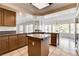 Open kitchen with granite countertops, tile floors, stainless steel refrigerator, and wooden cabinets at 902 Cripple Creek Ct, Henderson, NV 89014
