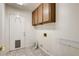 Functional laundry room with overhead cabinets, tile flooring, and utility connections at 902 Cripple Creek Ct, Henderson, NV 89014