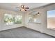 Bright living room with large windows and a ceiling fan, offering a comfortable and naturally lit space at 902 Cripple Creek Ct, Henderson, NV 89014