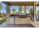 Well-equipped outdoor kitchen with a built-in stainless steel grill and a convenient mini fridge at 902 Cripple Creek Ct, Henderson, NV 89014