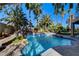 Sparkling backyard pool surrounded by lush landscaping, rock accents, and mature palm trees, ideal for relaxation and entertaining at 902 Cripple Creek Ct, Henderson, NV 89014
