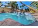 Backyard pool showcasing rock waterfall, mosaic tile accents, and inviting steps for easy access and relaxation at 902 Cripple Creek Ct, Henderson, NV 89014