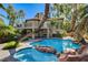 Resort-style pool with rock features and spa surrounded by lush landscaping and home with upper balcony at 902 Cripple Creek Ct, Henderson, NV 89014