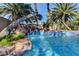 Inviting backyard pool with a rock waterfall feature, mature landscaping, and a serene atmosphere at 902 Cripple Creek Ct, Henderson, NV 89014