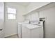 Efficient laundry room includes appliances and shelving for convenient storage at 9122 Mountain Maple Ct, Las Vegas, NV 89148