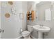 Charming half bathroom with a pedestal sink and decorative wall art at 106 Rock Crossing Ave, North Las Vegas, NV 89031