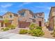 Two-story home featuring a two-car garage, desert landscaping, and a charming red front door at 106 Rock Crossing Ave, North Las Vegas, NV 89031